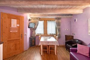 een woonkamer met een tafel en een bank bij Chalet Picchio Bilocale in Livigno