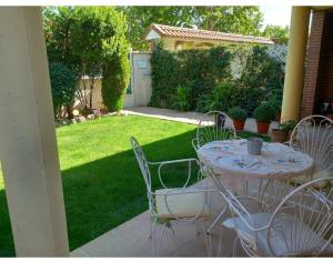 a table and chairs on a patio with a yard at Villa Lendi in Rivas-Vaciamadrid