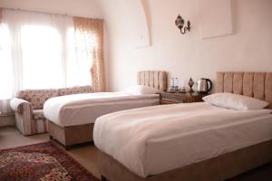 a hotel room with two beds and a window at Cappadocia Landscape House in Nevsehir