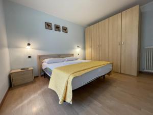 um quarto com uma cama grande e armários de madeira em Residence Valentino em Pinzolo