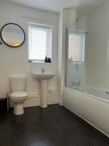 a bathroom with a toilet and a sink and a shower at Home Away from Home: Cozy Two Bedroom Apartment in Banbury