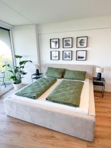 a large white bed in a room with a large window at Helles Apartment mit tollem Blick über Augsburg in Augsburg