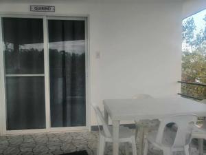 une table blanche et des chaises dans une pièce avec une fenêtre dans l'établissement COSTA DE ANGELO BOLO BEACH RESORT, à Alaminos 39 autres photos