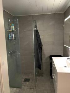 La salle de bains est pourvue d'une douche avec une porte en verre. dans l'établissement Kaunis huoneisto Turun Kakolassa, à Turku