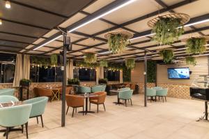 a restaurant with tables and chairs and a tv at Savoy Hotel ELMinya in Minya