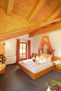 um quarto com uma cama grande e tectos em madeira em Landhaus Kostenzer mit Sauna em Fügen