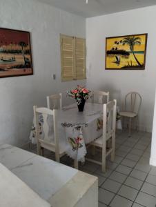 uma sala de jantar branca com uma mesa e cadeiras em Casa em Tamandaré a 1km de Carneiros no Condomínio Cote d' Azur em Tamandaré