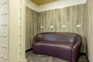un fauteuil en cuir brun dans une chambre avec des murs en bois dans l'établissement Kabannas Newcastle, à Newcastle upon Tyne