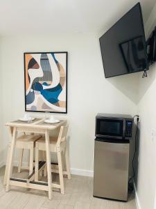 a kitchen with a table and a microwave and a television at Nuvole Guest Suite in Miami
