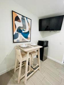 a table with two chairs and a television in a room at Nuvole Guest Suite in Miami