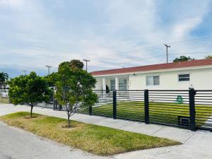 a house with a black fence and two trees at Nuvole Guest Suite in Miami