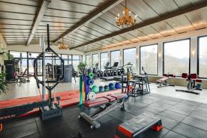 a gym with treadmills and machines in a room at Park Igls - Medical Spa Resort in Innsbruck