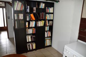 uma prateleira de livros negros cheia de livros numa sala em Le clos argoat em Pontivy
