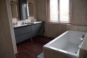 ein Badezimmer mit 2 Waschbecken und einer Badewanne in der Unterkunft Le clos argoat in Pontivy