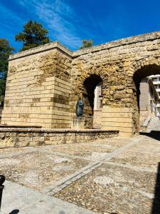 Una pared de ladrillo con una estatua encima. en APARTAMENTO LA MURALLA, en Córdoba