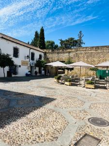 un patio con sombrillas y mesas y un edificio en APARTAMENTO LA MURALLA, en Córdoba