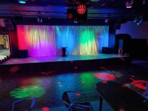 a stage with colorful curtains and a table with chairs at Cosy 2 Bed chalet Florida Holiday Park, Hemsby in Hemsby