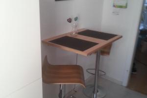 a desk with a chair and a table with a vase at Private Rooms in Hannover