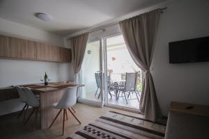 a kitchen with a table and chairs and a sliding glass door at Apartments Villa Rivarella in Novigrad Istria +4 photos