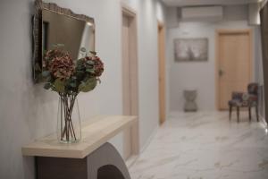 a vase of flowers on a table in a hallway at Rob Venture Suites at the central of ATHENS city in Athens