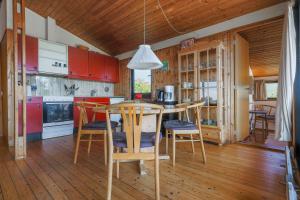 een keuken met houten vloeren en een tafel en stoelen bij Magnificent house with splendid view to the sea in Fåborg