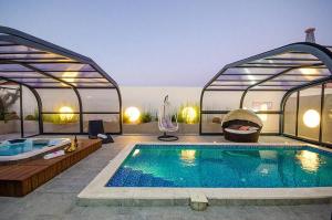 uma piscina com banheira de hidromassagem numa casa em סוויטות שלווה עילאית em Sifsufa