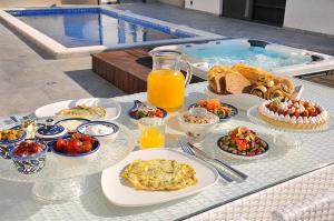 uma mesa com comida e bebidas e uma piscina em סוויטות שלווה עילאית em Sifsufa