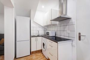 a kitchen with white cabinets and a washer and dryer at Casa Teresita in Arona +12 photos
