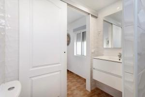 a white bathroom with a toilet and a sink at Casa Teresita in Arona