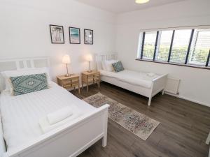 um quarto branco com uma cama e um sofá em Topsails em Freshwater