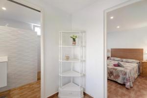 a bedroom with a white book shelf next to a bed at Casa Teresita in Arona