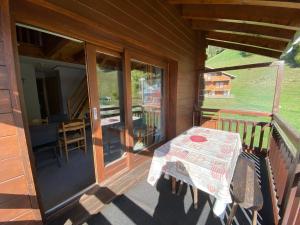 a porch of a house with a table and glass doors at Appartement lumineux, 8 personnes, 3 chambres, 1 mezzanine - OR16 in Beaufort