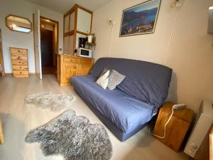 ein Wohnzimmer mit einem blauen Sofa und einer Mikrowelle in der Unterkunft Studio pied des pistes, 4 personnes, 1 pièces - PL2H in Beaufort