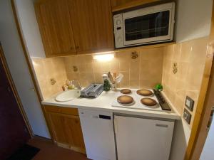 eine kleine Küche mit einer Spüle und einer Mikrowelle in der Unterkunft Studio pied des pistes, 4 personnes, 1 pièces - PL2H in Beaufort