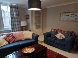 a living room with two blue couches and a table at The Hideaway in Peebles