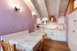 a kitchen with a table and chairs and a kitchen with white cabinets at Chalet Picchio Trilocale in Livigno