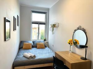 una piccola camera con letto e specchio di MMRent Sunflower Room a Danzica
