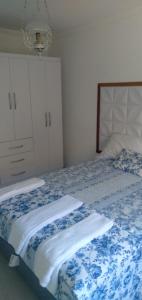a bedroom with a bed with a blue and white blanket at Casa de Campo em Lumiar com corrego ,lareira e churrasqueira in Lumiar