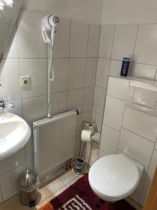 a bathroom with a toilet and a phone on the wall at Hannover Apartment 6 Personen - Nähe Messe in Hannover