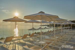 - un groupe de chaises longues et de parasols sur une plage dans l'établissement AluaSoul Zakynthos - Adults only - All Inclusive, à Tragaki
