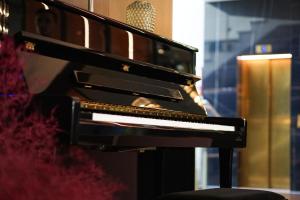 ein schwarzes Klavier in einem Zimmer mit einem Mikrofon in der Unterkunft Best Western Plus Delta Park Hotel in Mannheim