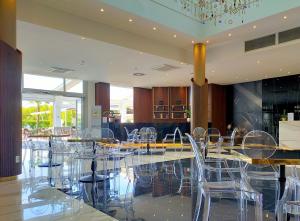 a dining room with chairs and tables and a chandelier at The Sydney Hotel in Bologna