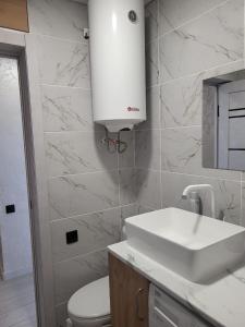 Baño blanco con lavabo y aseo en квартира по суточно, en Shchūchīnsk