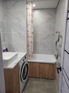 y baño con lavadora y bañera. en квартира по суточно, en Shchūchīnsk