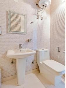 bagno bianco con lavandino e servizi igienici di HOTEL THE LAZEEZ a Nuova Delhi