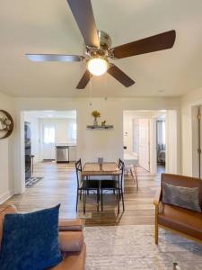 a living room with a table and a ceiling fan at 2BR Cedar Lane Road Retreat at Swamp Rabbit Trail! in Greenville