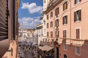 un gruppo di persone che camminano per una strada tra edifici di Corso Miracle Suite a Roma