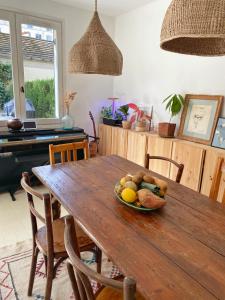 un tavolo in legno con un cesto di frutta sopra di Maison de charme pour les JO 2024 a Puteaux