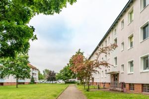 a building with a grass field next to it at Private Apartment in Hannover