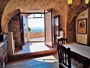 una cocina con mesa de comedor y una gran puerta de cristal en Dimora Porta Venere en Spello